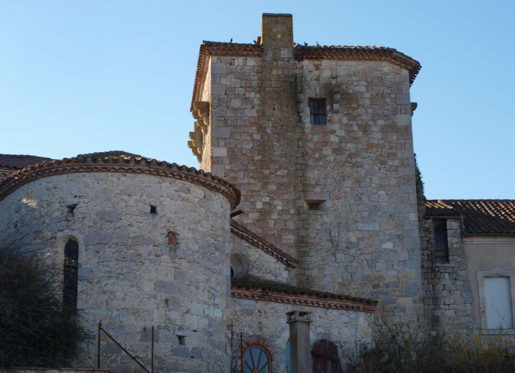 Tour du château avec sur la gauche l'église et sur la droite le presbytère